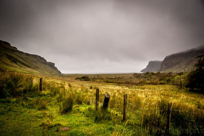 Scenic view of field against cloudy sky