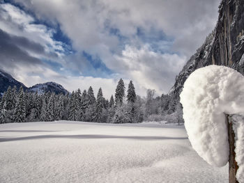 Close-up of snow covered field against sky