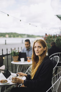 Portrait of female freelancer sitting with laptop at cafe