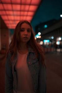 Portrait of young woman standing at night