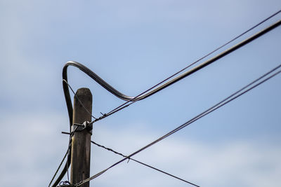 Low angle view of bird perching on metal against sky