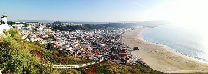 High angle view of town by sea against sky