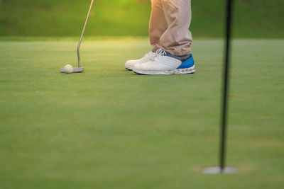 Low section of man playing golf on course