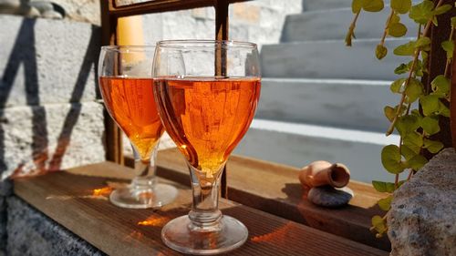 Close-up of two drinks of aperol  standing at the window shining in the sun