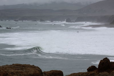 Scenic view of rocks on beach against sky