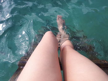 Low section of woman relaxing in swimming pool