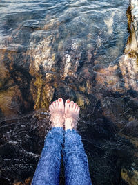 Low section of person on rock in sea