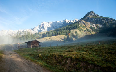 Road by mountains against blue sky