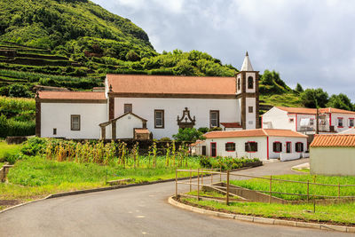 Houses by road against buildings in city