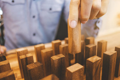 Midsection of man arranging wooden blocks on table