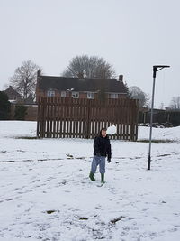 Full length of girl walking on snow covered landscape