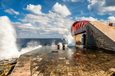 People on sea shore against sky