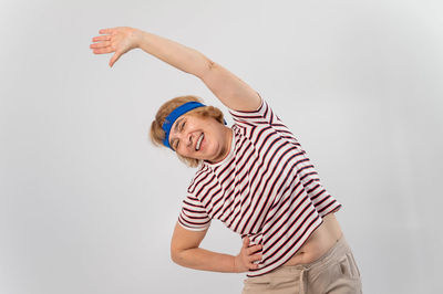 Portrait of smiling young woman against white background