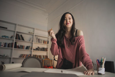 Smiling asian woman in a creative studio