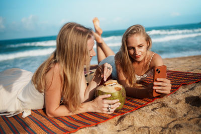 Portrait of friends sitting at beach