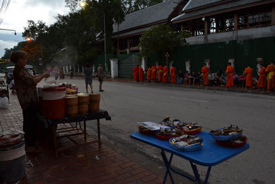 People on table by street in city