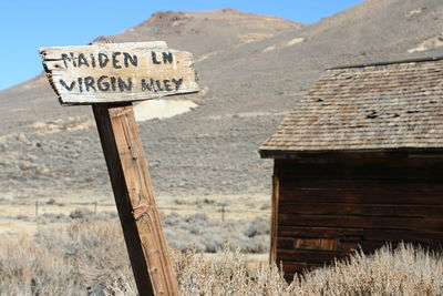 Information sign on field against mountain range