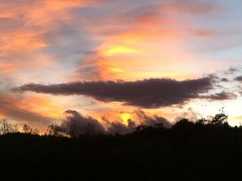 Silhouette of landscape against cloudy sky