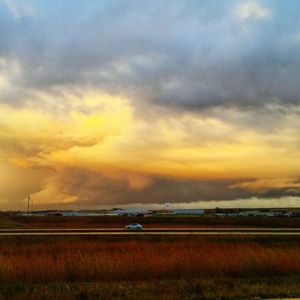 Scenic view of agricultural field against dramatic sky