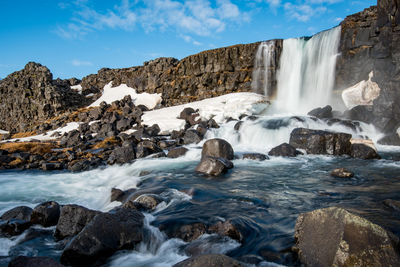 Scenic view of waterfall against sky