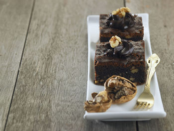 Close-up of cake and walnut in tray on table