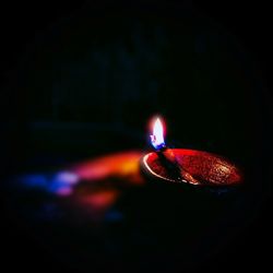 Close-up of lit candle in the dark