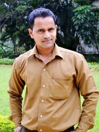 Portrait of smiling man standing at park