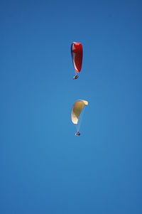 Low angle view of parachute against blue sky
