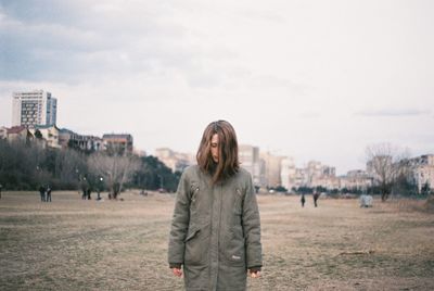 Portrait of young woman standing against sky