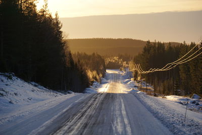 Snow covered road against sky