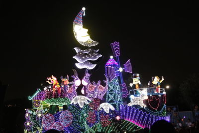 Low angle view of illuminated christmas lights against sky at night