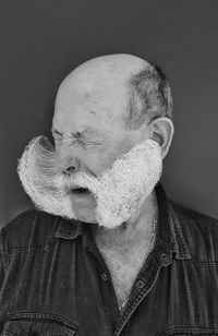 Portrait of man wearing mask against gray background