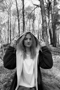 Portrait of woman wearing hood clothing while standing in forest