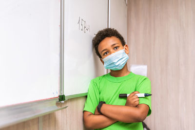 Cute boy standing by whiteboard