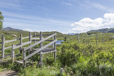 Wooden fence on field against sky