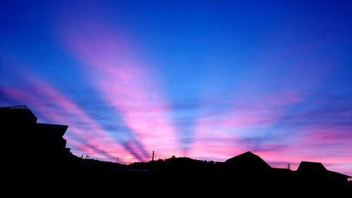 Low angle view of silhouette buildings against sky at sunset