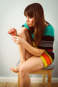 Young woman sitting on wall