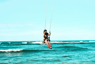 Man surfing in sea against sky