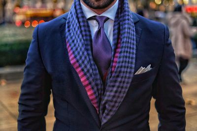 Midsection of man wearing suit while standing outdoors