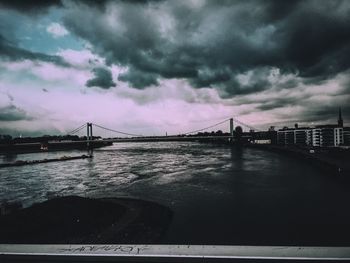 Bridge over river against cloudy sky