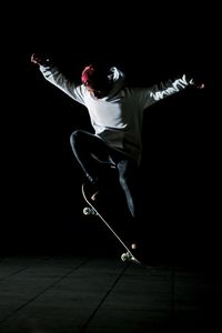 Young woman jumping on black background