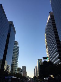 Low angle view of skyscrapers against clear blue sky