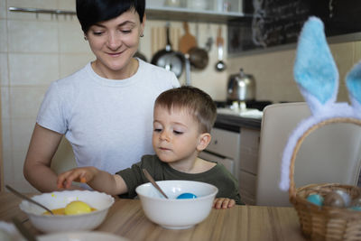 Portrait of smiling boy sitting on table at home