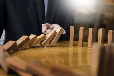 Midsection of businessman holding on wooden blocks