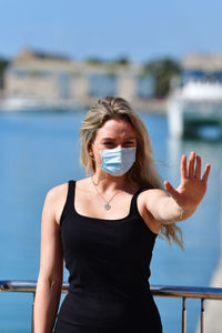 Portrait of woman standing against sea