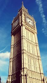 Low angle view of clock tower against cloudy sky