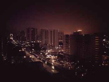 Illuminated cityscape against sky at night