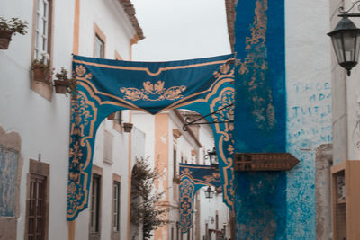 Low angle view of ornate hanging outside building