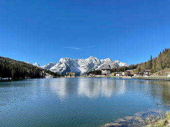 Scenic view of lake and mountains against blue sky