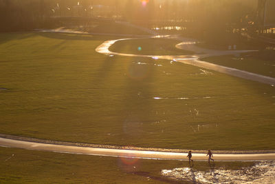 Friends walking on field at park during morning